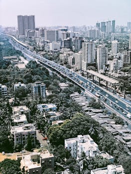 Aerial view of vibrant Mumbai cityscape with high-rise buildings and busy highway.